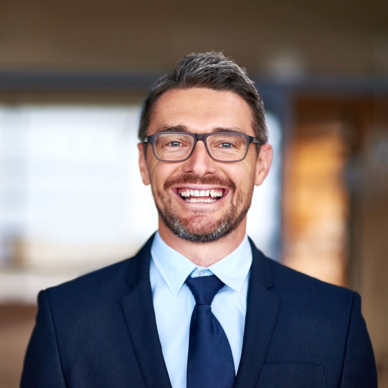 Uomo sorridente con occhiali e abito blu navy